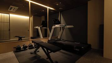 A gym with exercise equipment, including a treadmill and dumbbells.