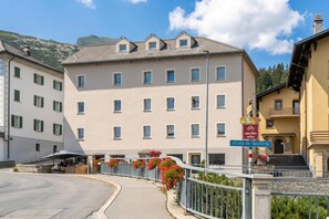 Ein mehrstöckiges Hotel mit Innenhof, einem Radwegweiser und einem Straßenschild mit der Aufschrift 'Strada de l'Acuforta'.