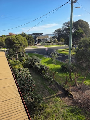 A residential street with a 'Give Way' sign, a wooden fence, and a variety of greenery. - Seaside location close to all amenities (San Remo)