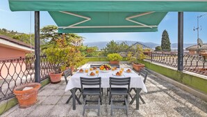 A terrace with a table set for breakfast, surrounded by potted plants and overlooking a scenic landscape. - Roma 62 Lake View,Terrace & Private Park, Toscolano Maderno, Italy (Toscolano Maderno)