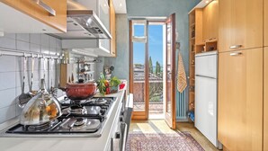 A kitchen with a stove, cabinets, and a view to the outside. - Roma 62 Lake View,Terrace & Private Park, Toscolano Maderno, Italy (Toscolano Maderno)