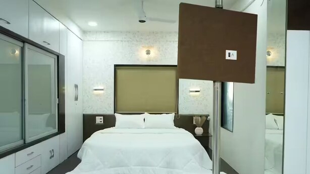 Et moderne hotelværelse med en stor seng, et klædeskab og et spejl.