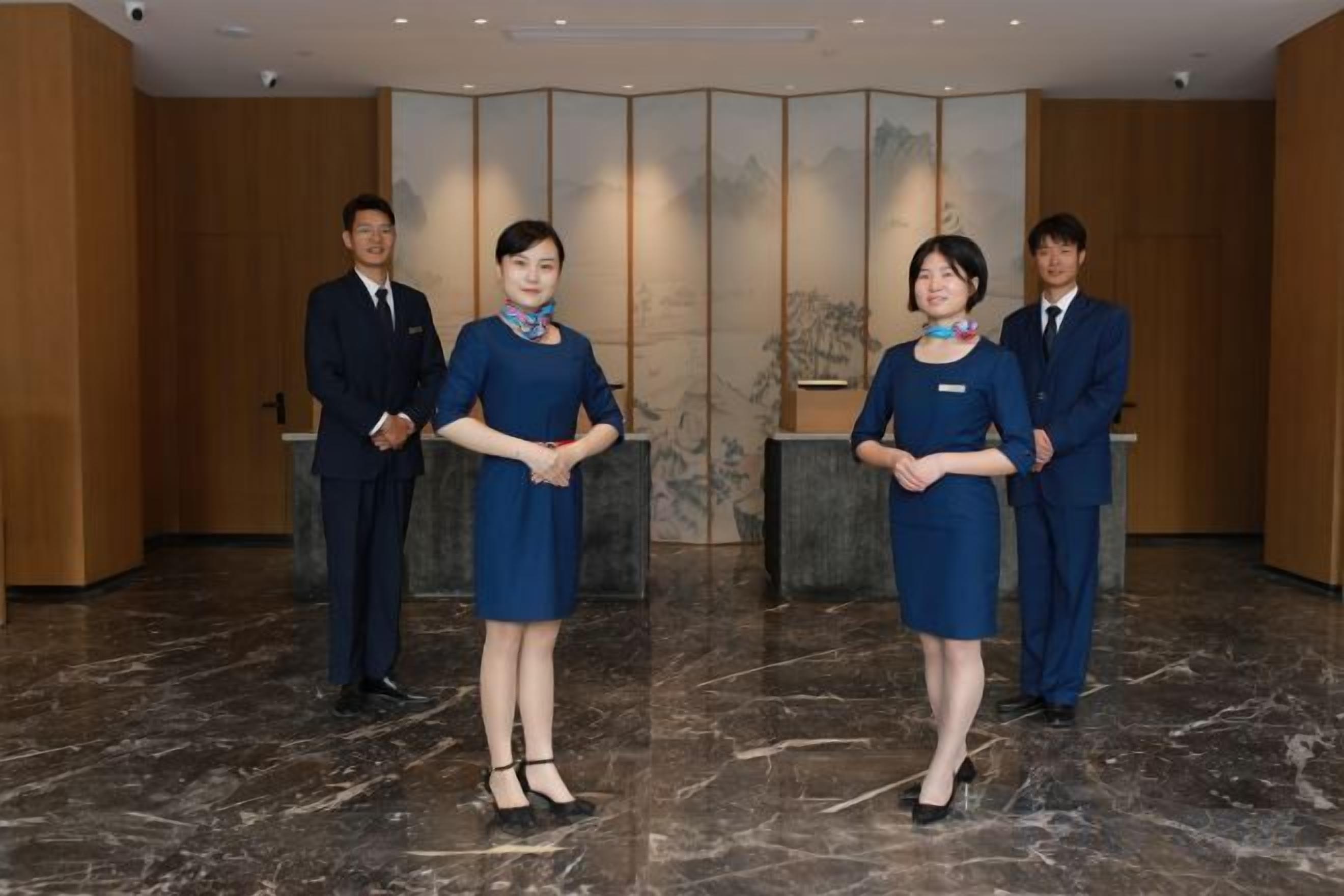 A reception area with a marble floor, wooden paneling, and a reception desk.