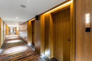 A hotel corridor with wooden doors and a patterned carpet. - MEHOOD LESTIE Hotel (Nanchang Tengwang Pavilion) (Nanchang)
