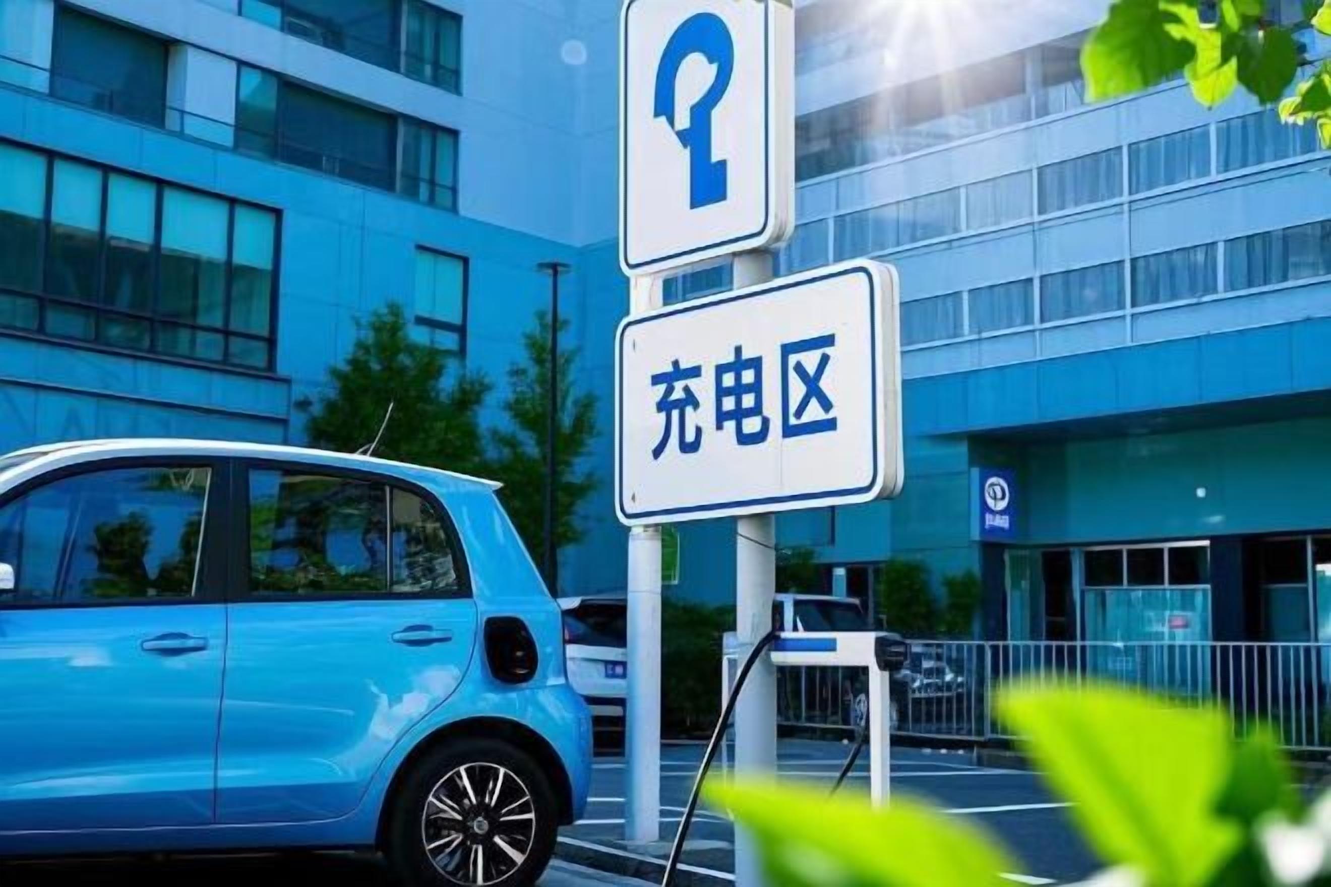 Un estacionamiento con un auto azul y un cartel que indica zona de carga.