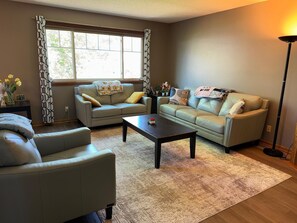Ein Wohnzimmer mit zwei Sofas, einem Couchtisch und einer Stehlampe.