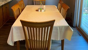 Un comedor con una mesa, sillas, un ventilador de techo y una ventana.