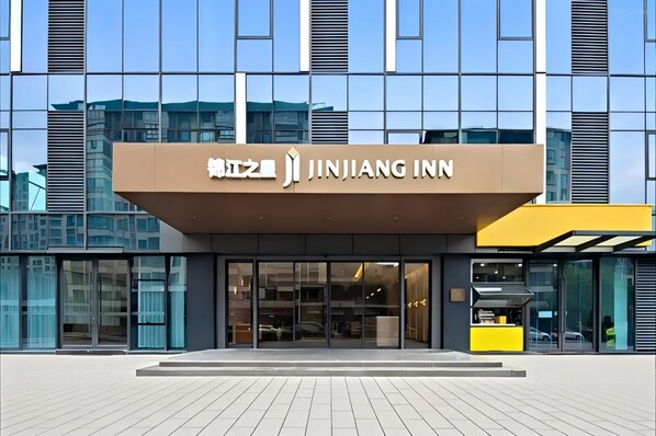 Ein modernes Gebäude mit einer deutlichen Beschilderung für Jinjiang Inn.