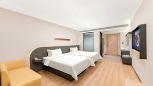 A modern hotel room with two beds, a desk, a chair, and a television. - Jinjiang Inn (Wuhan)
