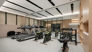 A gym with treadmills, elliptical machines, and a rack of dumbbells. - Jinjiang Inn (Wuhan)