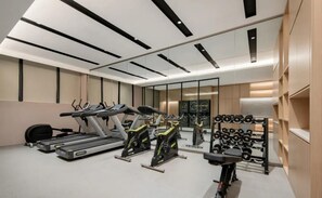 A gym with treadmills, elliptical machines, and a rack of dumbbells. - Jinjiang Inn (Wuhan)