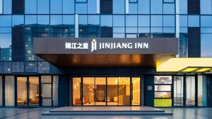 A modern hotel entrance with a sign reading 'JINJIANG INN' and a glass facade. - Jinjiang Inn (Wuhan)