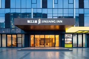 A modern hotel entrance with a sign reading 'JINJIANG INN' and a glass facade. - Jinjiang Inn (Wuhan)