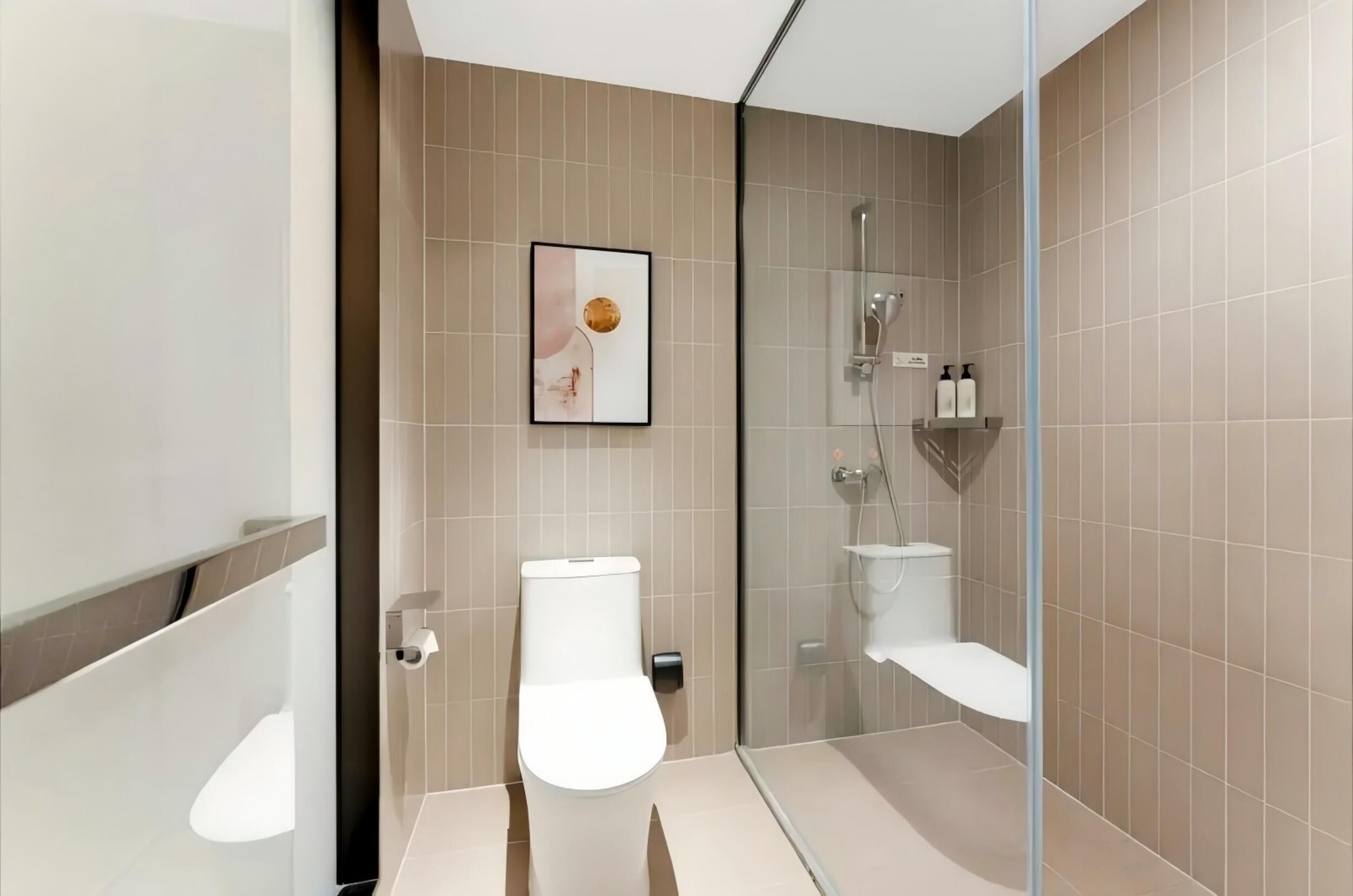A modern bathroom with a glass shower enclosure, a toilet, and a bidet.