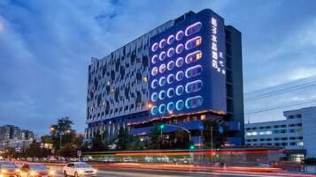 Un edificio moderno con una fachada distintiva y ventanas circulares iluminadas.
