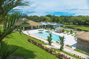 A resort with a swimming pool, lounge chairs, and a thatched-roof structure. - Pool, Yoga Studio -Private La Vibra Resort Villa 4 (Langostino)