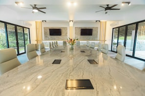 A conference room with a marble table, beige chairs, ceiling fans, and large windows. - Pool, Yoga Studio, Private-La Vibra Resort Villa 6 (Langostino)
