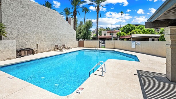 A swimming pool with a diving board, lounge chairs, and palm trees in the background. - NEW Gorgeous Townhome, Beautiful Balcony, Centrally Located at 44th St/Camelback (Phoenix)