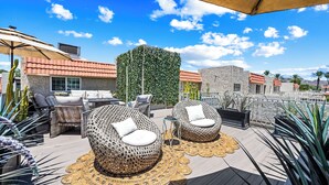 An outdoor seating area with wicker furniture and a decorative wall. - NEW Gorgeous Townhome, Beautiful Balcony, Centrally Located at 44th St/Camelback (Phoenix)
