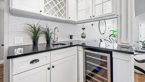 A kitchen with white cabinetry, a black countertop, and a built-in wine cooler. - NEW Gorgeous Townhome, Beautiful Balcony, Centrally Located at 44th St/Camelback (Phoenix)