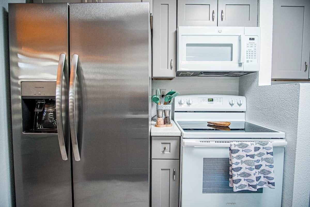 A kitchen with a stainless steel refrigerator, a microwave, and a stove.
