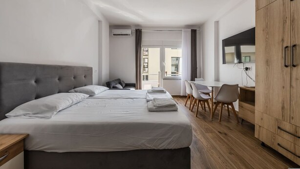 Une chambre d’hôtel avec un grand lit, un bureau et une armoire.