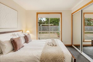 A hotel room with a bed, a large window, and a view of the outdoors. - Modern 3BR Retreat | Near Launceston CBD (Youngtown)