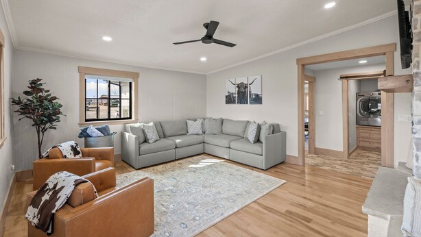 Una sala moderna con un sofá modular, una mesita de centro, una planta en maceta y un ventanal grande.