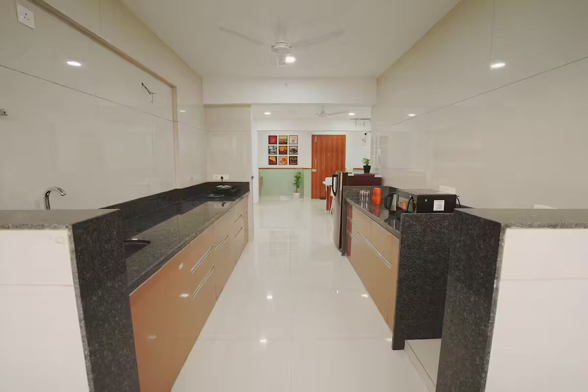 A modern kitchen with a central island, white cabinetry, and a ceiling fan.