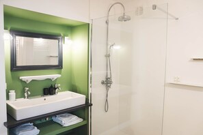 A bathroom with a white sink, a mirror, and a glass-enclosed shower. - Les Sentiers de Solutré Room (FUISSE)