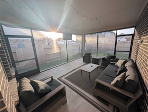Un espace extérieur aménagé, abrité et doté d’un canapé, de chaises et d’une table basse.