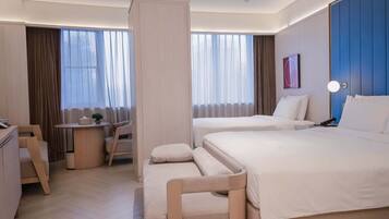 Een hotelkamer met twee bedden, een bureau en een stoel.