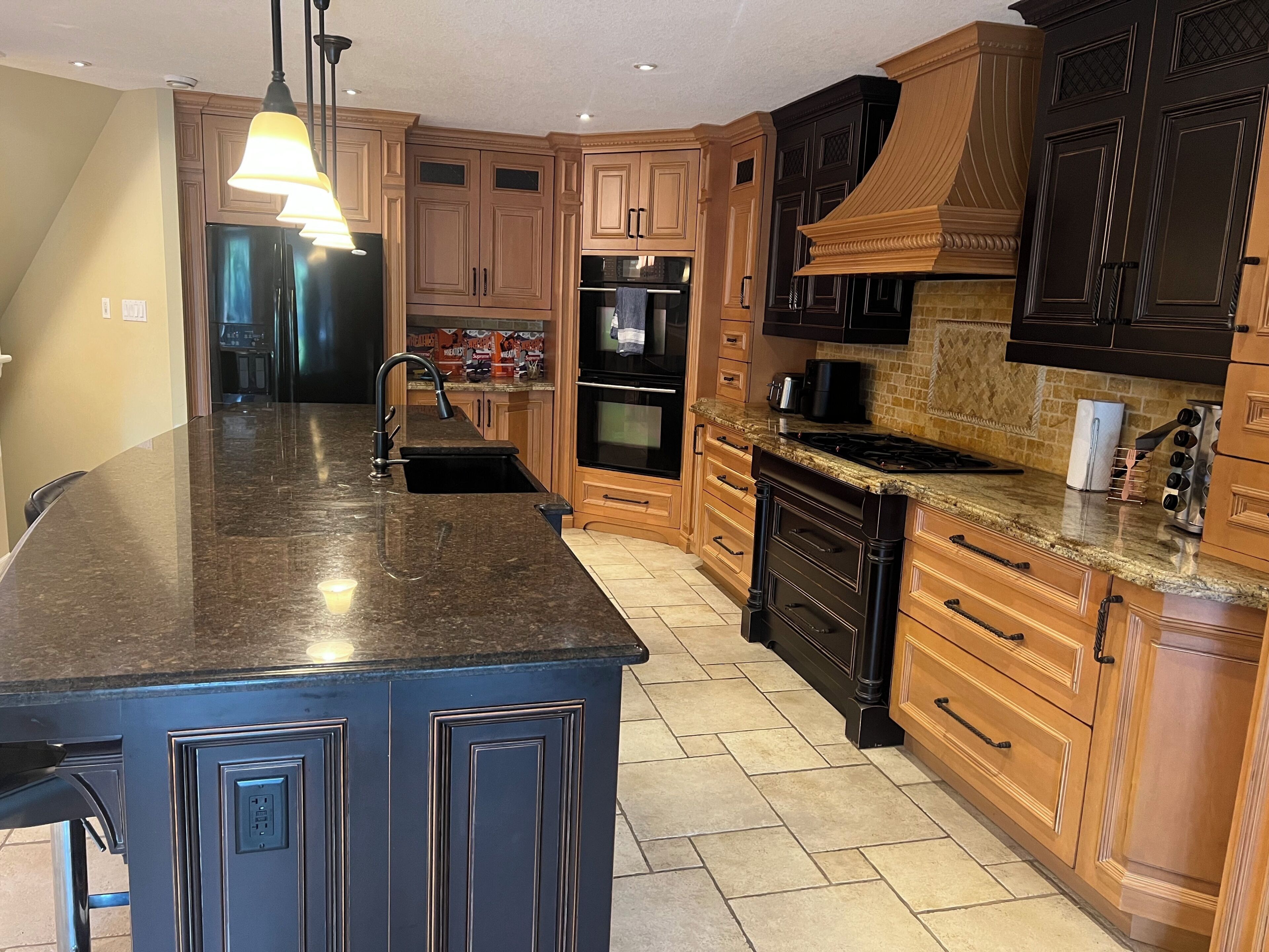 A kitchen with a central island, wooden cabinets, a stove, and a microwave.