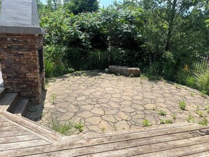A stone patio with a brick wall and wooden deck. - Private Home w/ 5 bedrooms, 3.5 baths, office, 3 living rooms, & HOT TUB. (London)