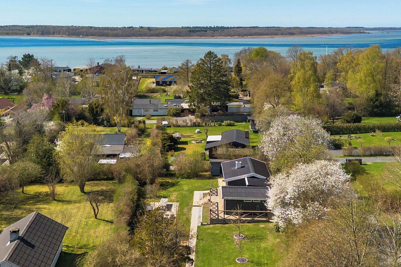 A residential area with houses, a lake, and a forested landscape.
