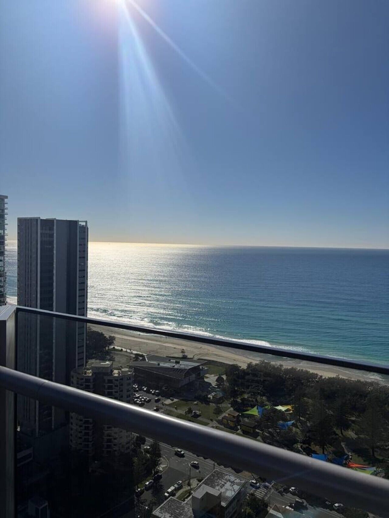 A high-rise building with a view of the ocean and a beach.