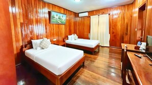 A hotel room with wooden paneling, two single beds, a desk with a chair, and a television. - ASANA (Siem Reap)