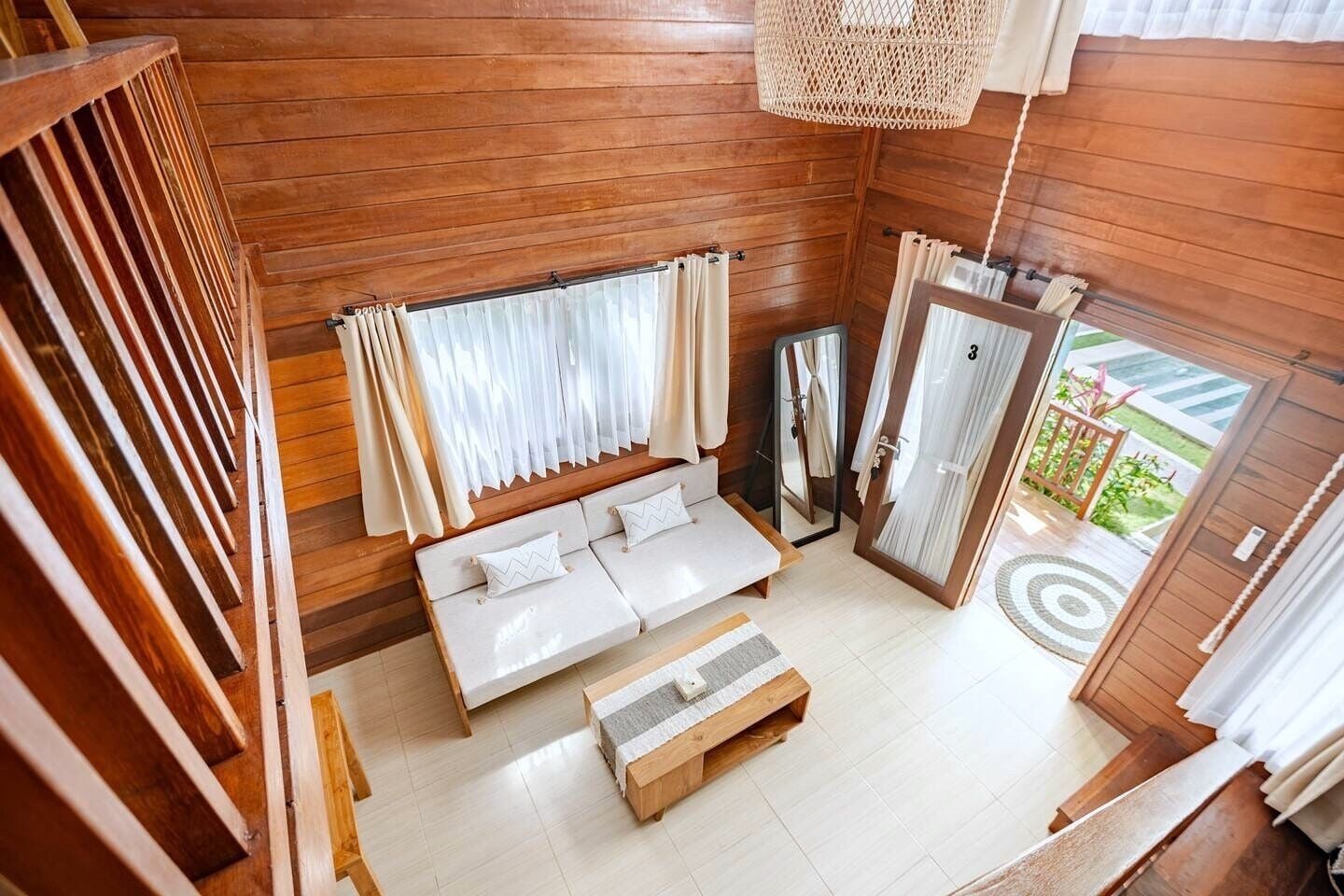 A wooden interior with a sofa, a bench, and a mirror.