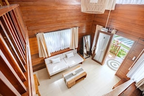 Un intérieur en bois avec un canapé, un banc et un miroir.