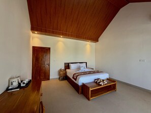 A hotel room with a wooden ceiling, a bed with a wooden headboard, a bedside table, and a wooden bench at the foot of the bed. - Atta Residence (Karangasem)