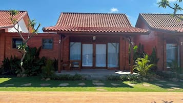Una casa de dos pisos con techo de tejas, un porche delantero y una piscina.