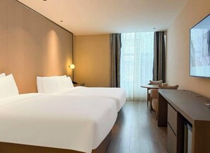Ein Hotelzimmer mit einem großen Bett, einem Schreibtisch und einem Stuhl.