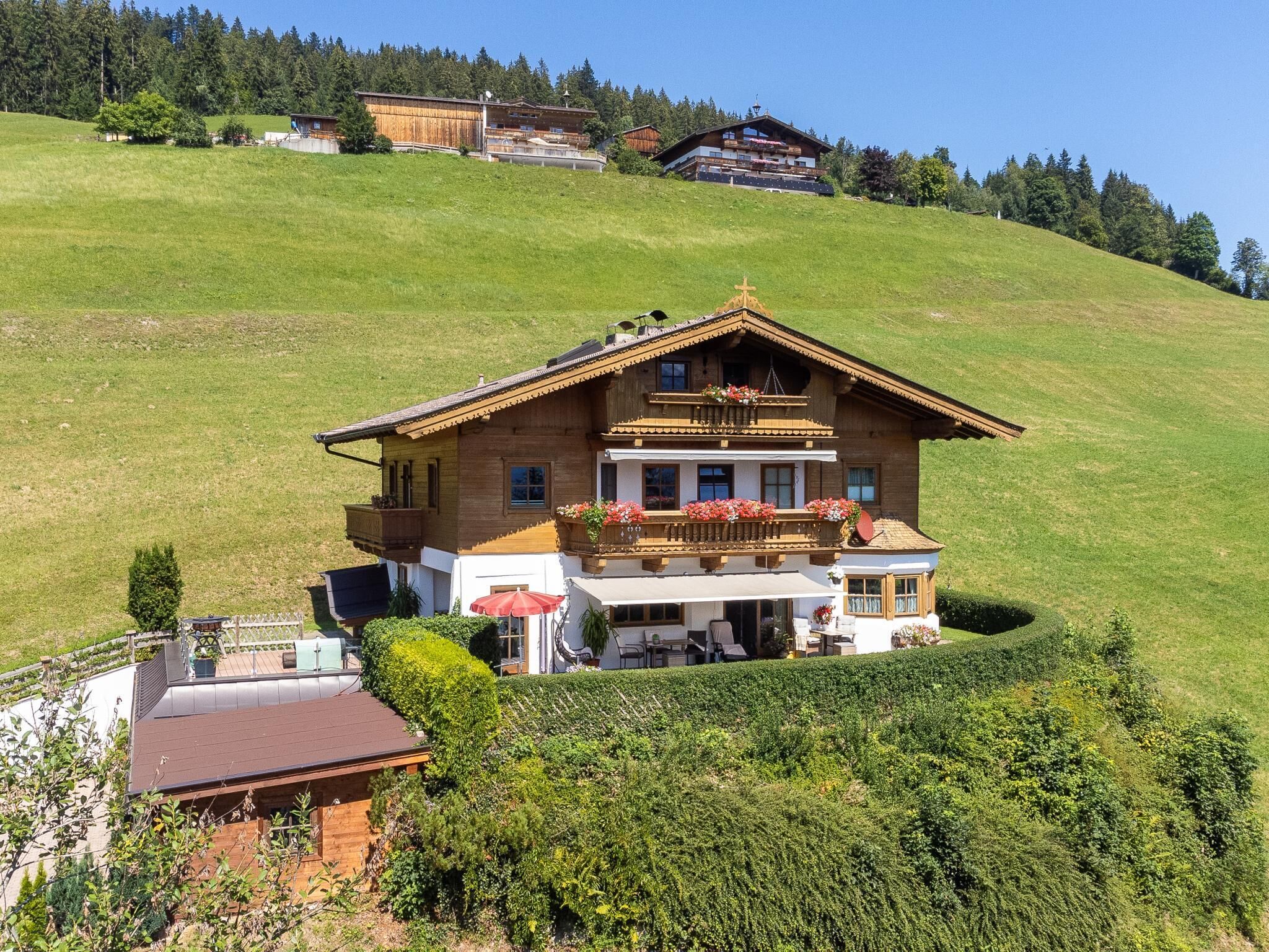 Un chalet doté d’un balcon, d’une terrasse couverte et offrant une vue sur les collines environnantes.