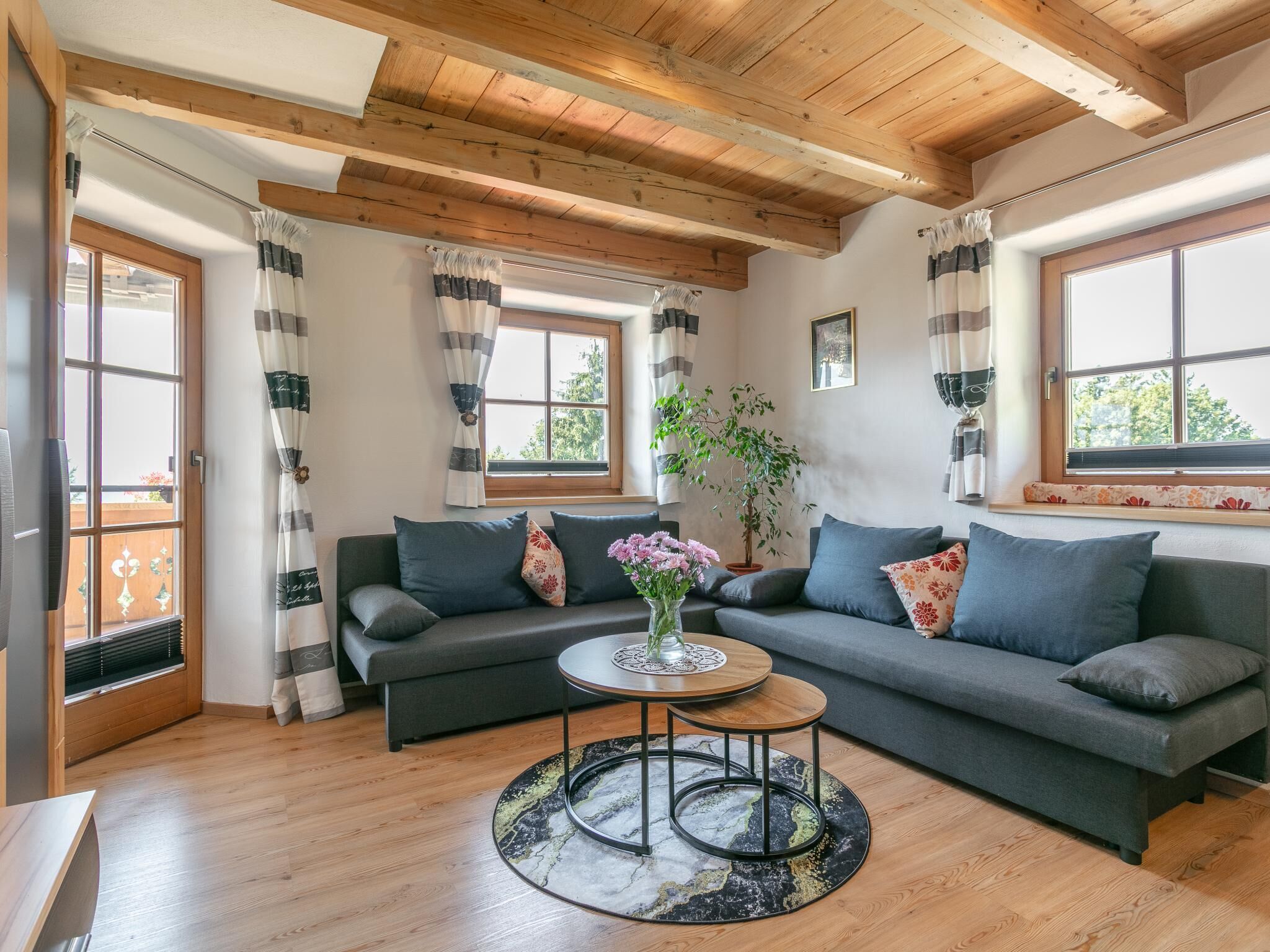 A living room with a sofa set, a coffee table, and a potted plant.