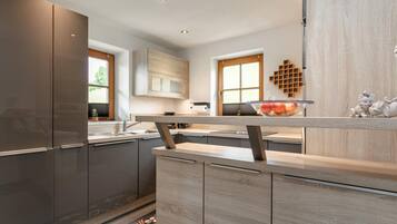 Eine moderne Küche mit integriertem Kühlschrank, Holzschränken und einer zentralen Kochinsel.