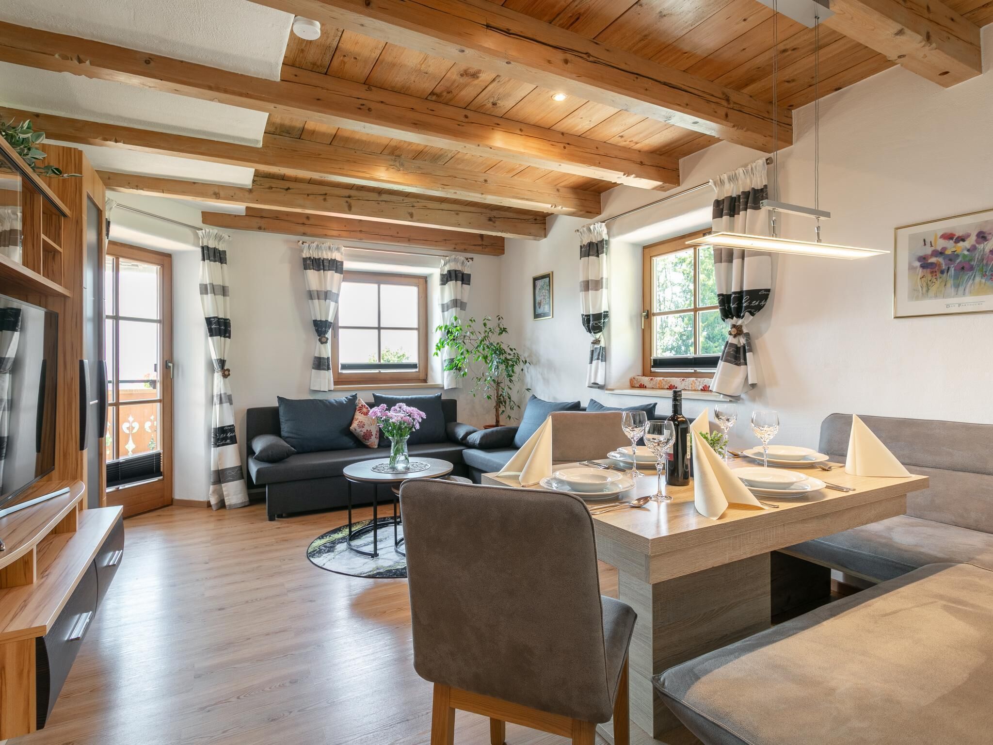 Een moderne woonkamer met een bank, salontafel en eethoek, klaar voor een maaltijd.