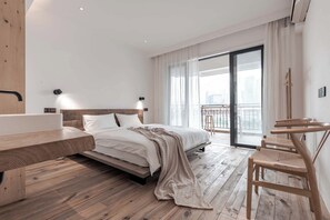 A modern bedroom with a wooden floor, a bed with a headboard, a bedside table, a chair, and a balcony with a view. - Boys2men (Chongqing)