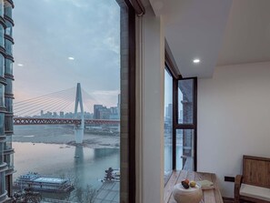 A modern interior with a large window overlooking a river and a bridge. - Boys2men (Chongqing)