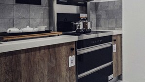Uma cozinha moderna com forno embutido, fogão e bancada de madeira.