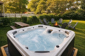 A hot tub in a backyard with a fire pit and outdoor seating. - Spacious home ft. backyard with exclusive hot tub! (Louisville)